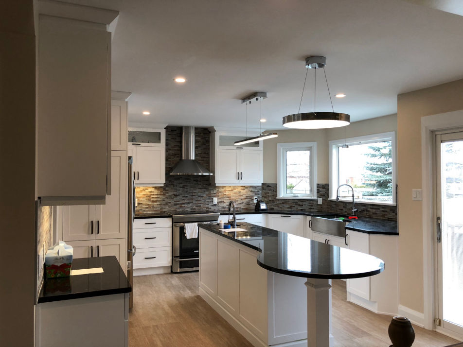 Modern, white kitchen with dark countertops